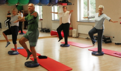 Sportler einbeinig auf einem Balancekissen